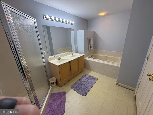 a bathroom with a tub sink and mirror