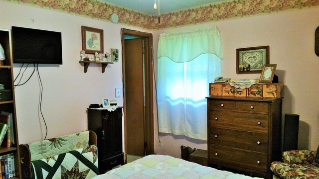 204 Phyllis Avenue Rochelle, IL 61068 - Photo 8 of 12 a bedroom with a bed and a flat tv screen on dresser