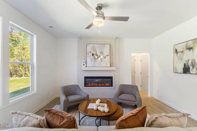 a living room with furniture a fireplace and a large window