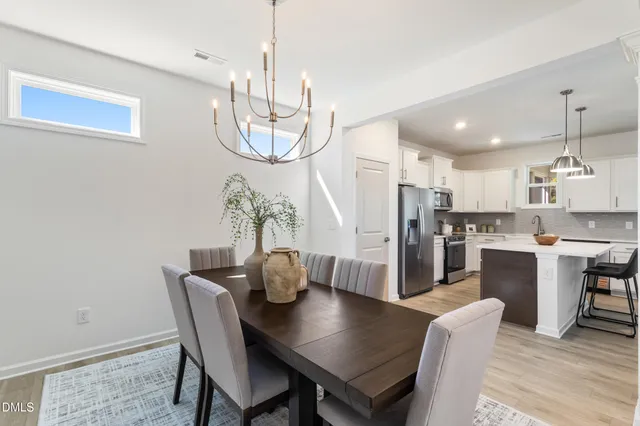 a view of a dining room with furniture wooden floor and chandelier