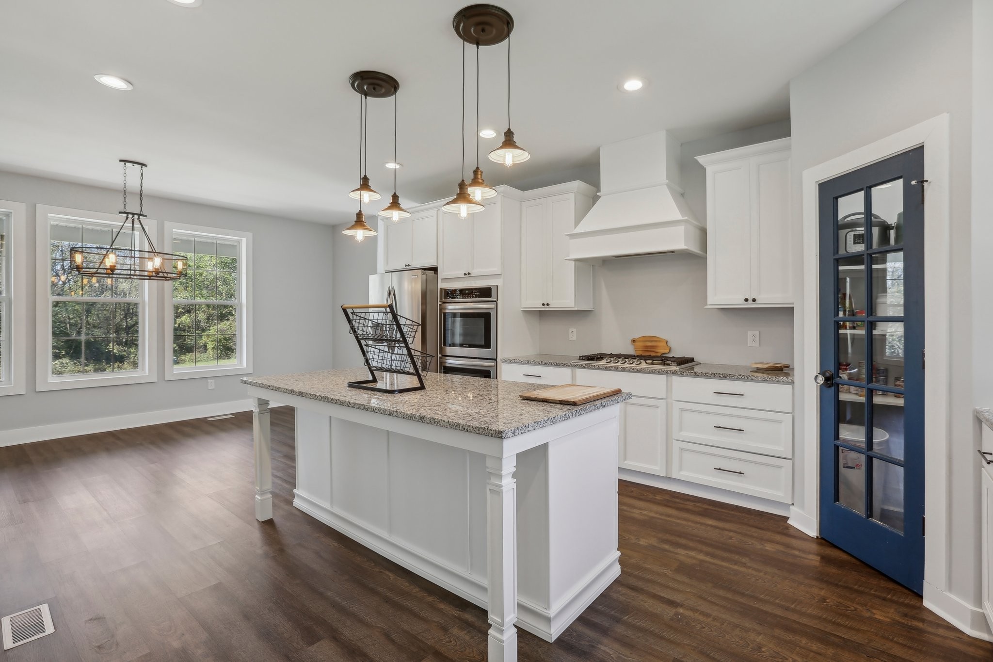 521 Boiling Springs Road Portland, TN 37148 - Photo 18 of 61 a kitchen with stainless steel appliances granite countertop a stove a sink dishwasher a refrigerator and a dining table with wooden floor