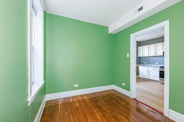 a view of a room with wooden floor and a bathroom