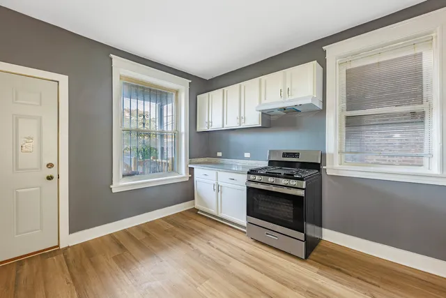a kitchen with a stove a sink and a window