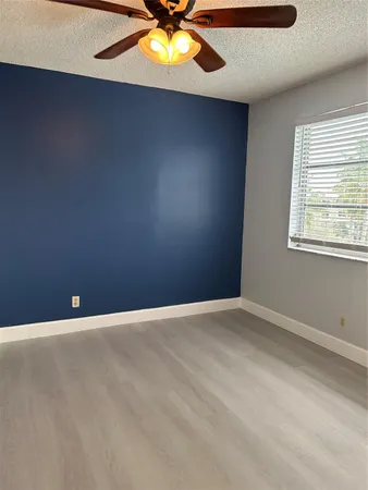 an empty room with a window and a ceiling fan