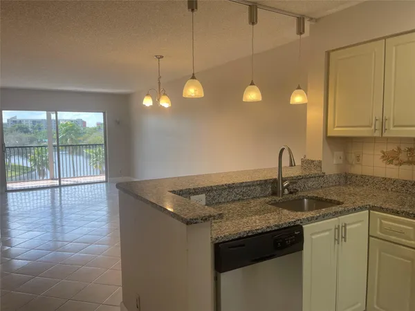 a kitchen with a sink cabinets and wooden floor