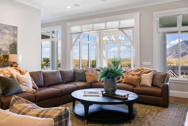 115 East Hidden Ridge Lane, Unit 42 Mapleton, UT 84664 - Photo 80 of 103 Spacious living area featuring extensive window-work with mountain scenery, crown molding, a built-in ceiling speaker, and a chandelier lighting fixture