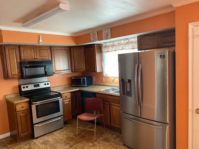a kitchen with stainless steel appliances a refrigerator stove microwave and sink