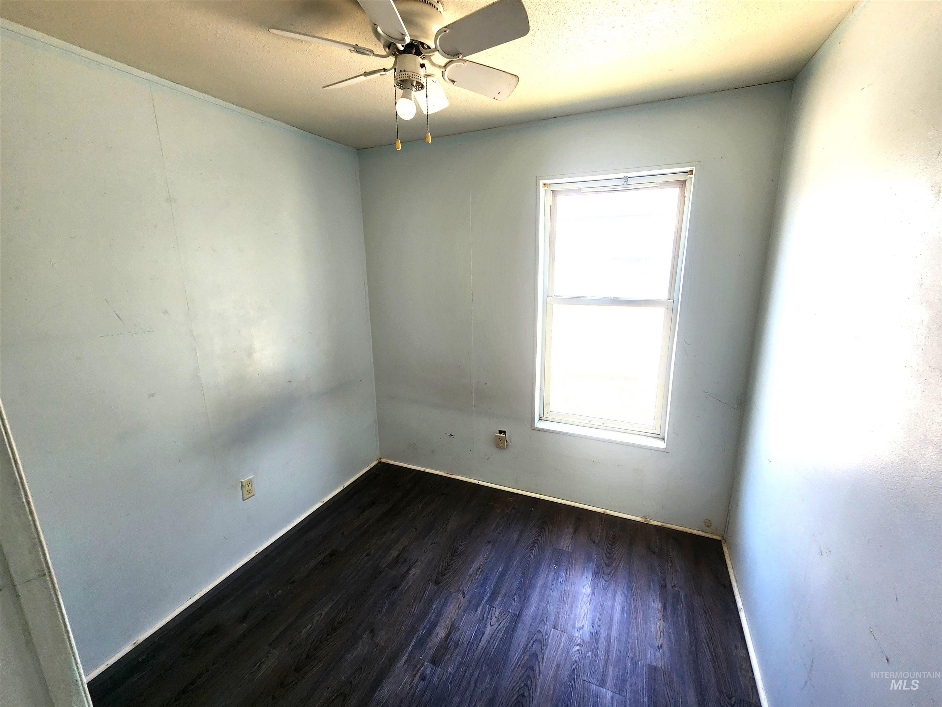 616 North Kings Road Nampa, ID 83687 - Photo 8 of 12 Room with dark wood-finish flooring, a single window, and a ceiling fan with light fixture