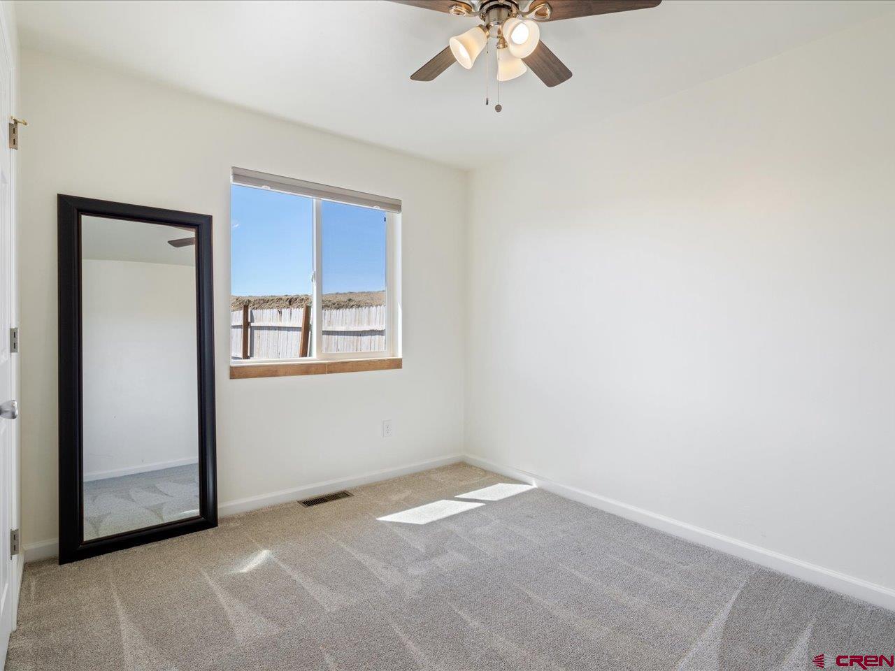 3580 Ruth Lane Delta, CO 81416 - Photo 21 of 35 an empty room with a chandelier fan and windows