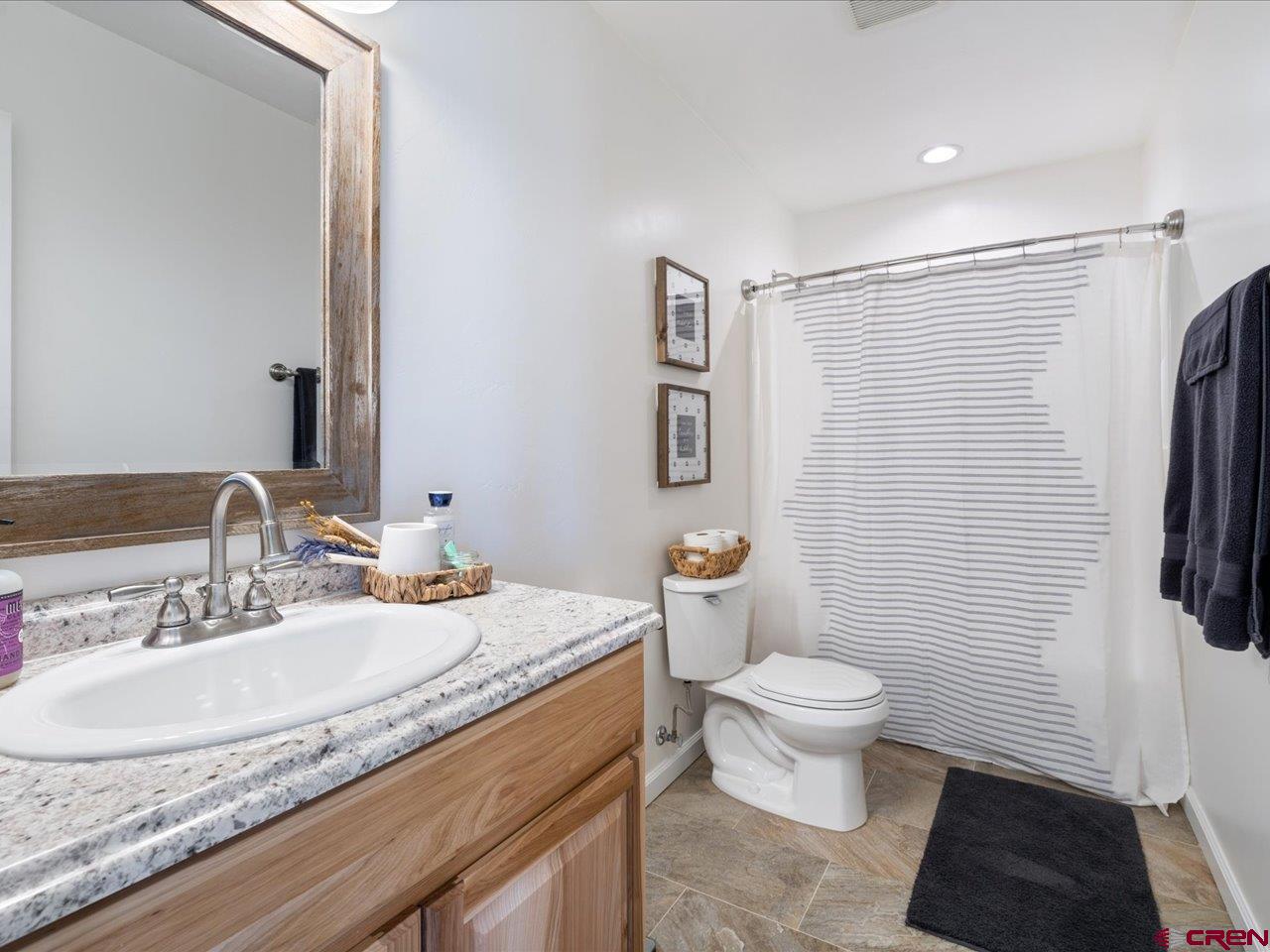 3580 Ruth Lane Delta, CO 81416 - Photo 22 of 35 a bathroom with a granite countertop toilet a sink and a mirror