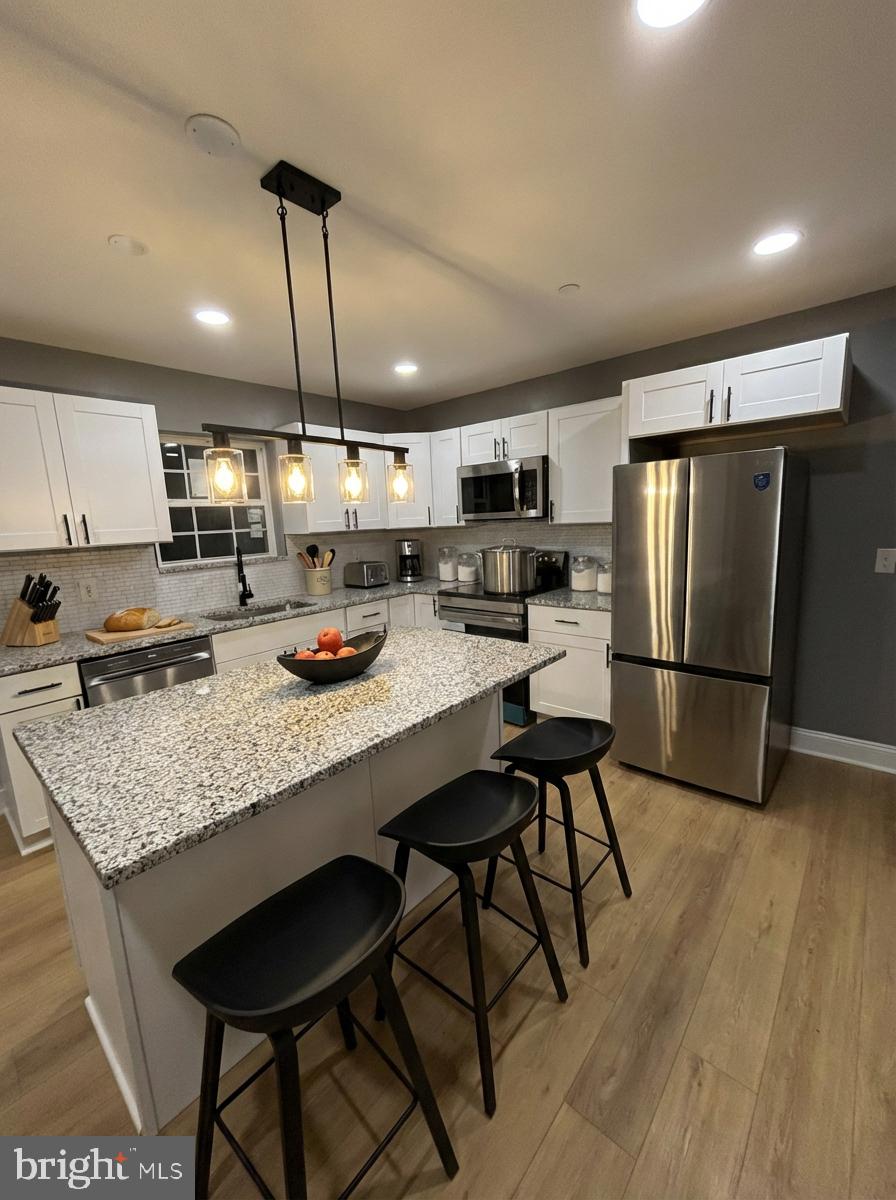 7544 Maury Road Windsor Mill, MD 21244 - Photo 5 of 14 a kitchen with stainless steel appliances granite countertop a sink refrigerator and cabinets