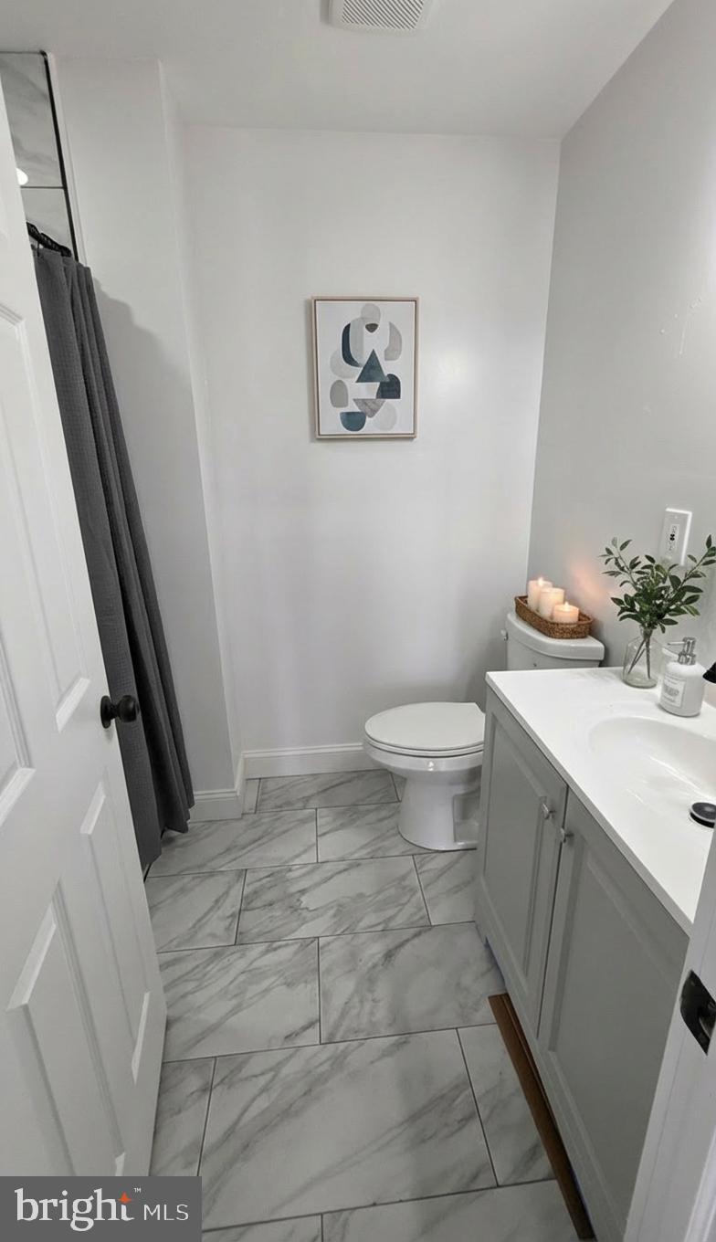 7544 Maury Road Windsor Mill, MD 21244 - Photo 8 of 14 a bathroom with a sink a toilet and a mirror