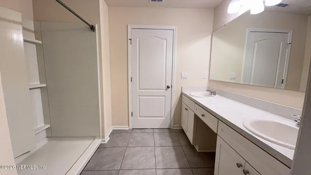 a spacious bathroom with a sink and a mirror