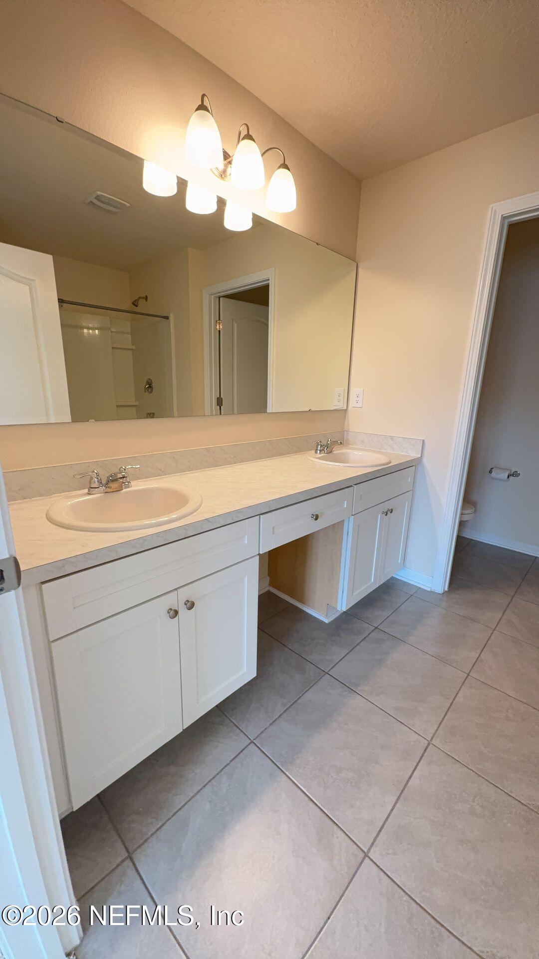 144 Redbud Road Palm Coast, FL 32137 - Photo 18 of 29 a spacious bathroom with a sink and a mirror