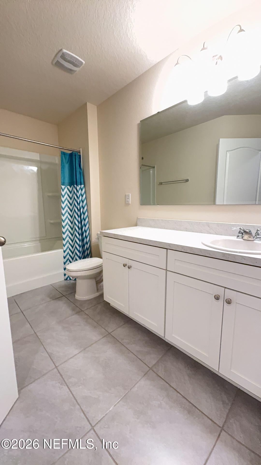144 Redbud Road Palm Coast, FL 32137 - Photo 25 of 29 a bathroom with a sink a mirror and a bathtub