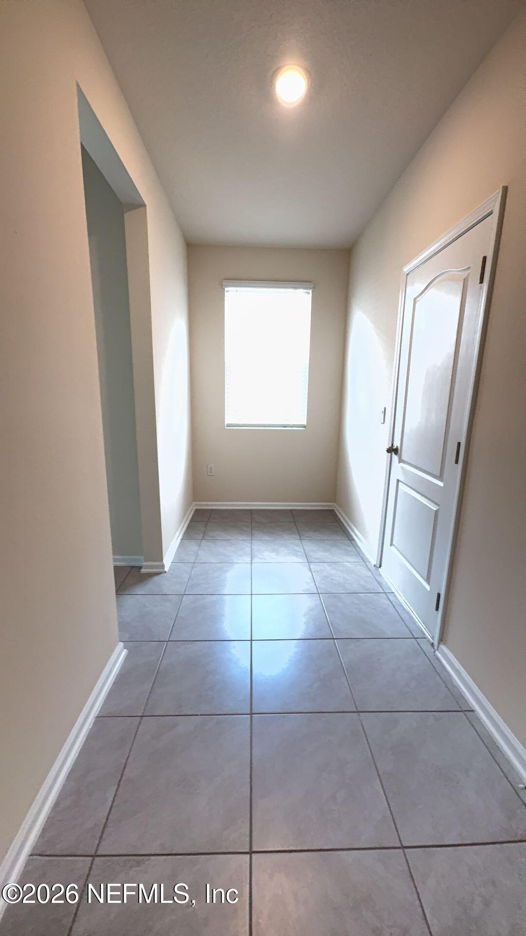 144 Redbud Road Palm Coast, FL 32137 - Photo 6 of 29 an empty room with a mirror and windows