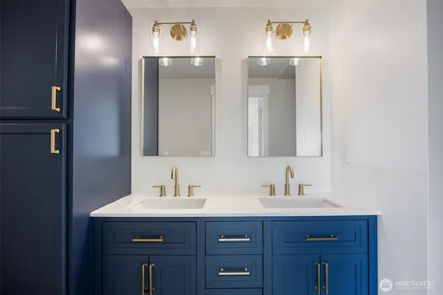 a bathroom with a sink and two mirror