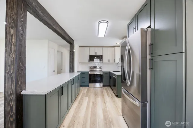 a kitchen with stainless steel appliances a refrigerator and a stove top oven