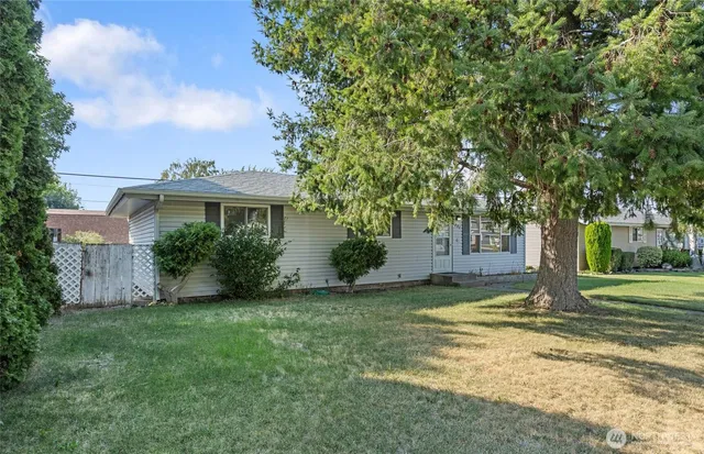 a view of a house with a yard and tree s