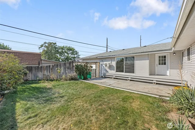 a view of a house with a yard and potted plants