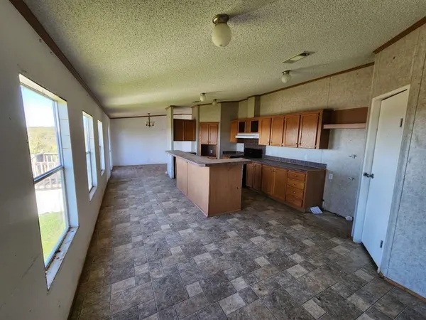a kitchen with granite countertop a stove refrigerator and microwave