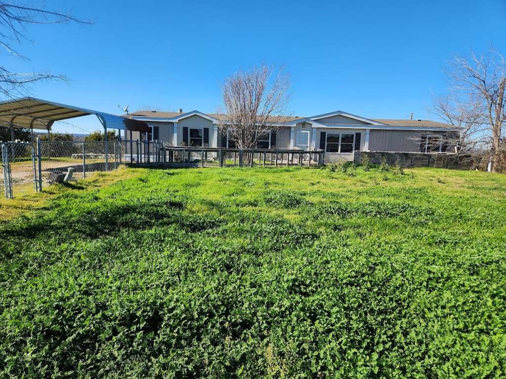 7640 Wd Court Lipan, TX 76462 - Photo 2 of 12 a front view of a house with a garden