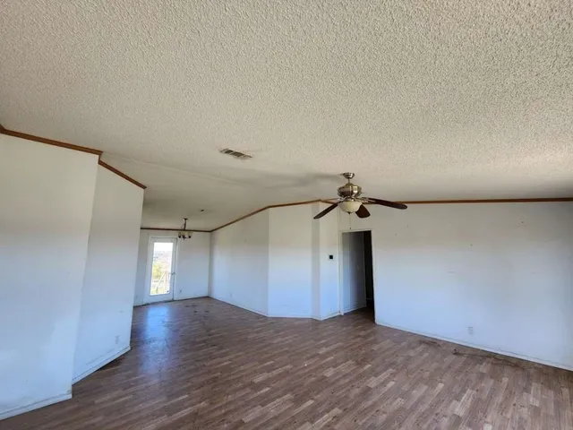 a view of a livingroom with a ceiling fan and wooden floor