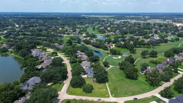 an aerial view of residential houses with outdoor space and trees