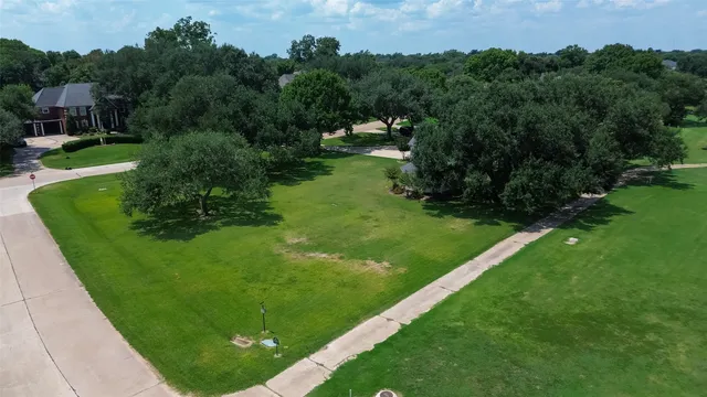 an aerial view of residential houses with outdoor space and trees