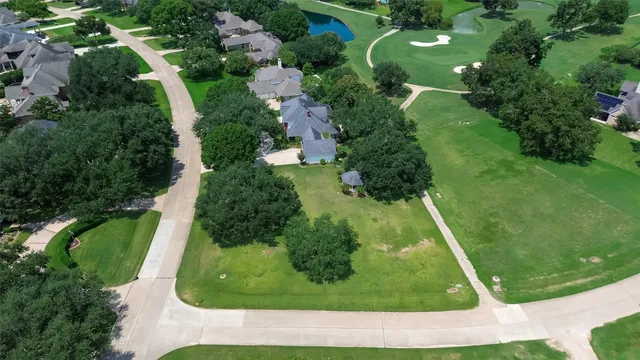 an aerial view of residential houses with outdoor space and trees