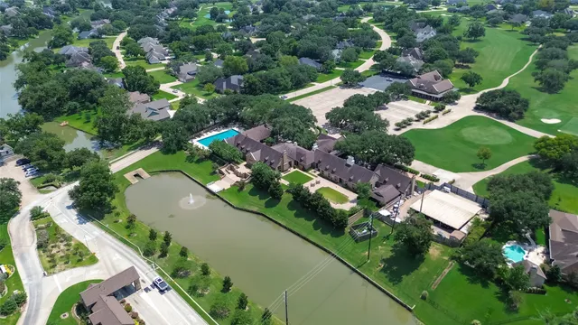 an aerial view of residential houses with outdoor space and trees