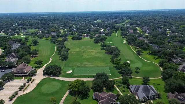 an aerial view of green landscape with trees houses and mountain view