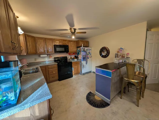 a kitchen with stainless steel appliances kitchen island granite countertop a stove refrigerator and microwave