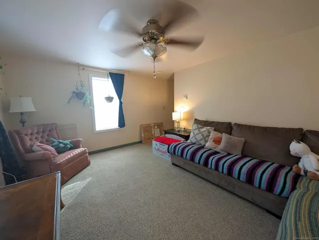 a living room with furniture and a ceiling fan