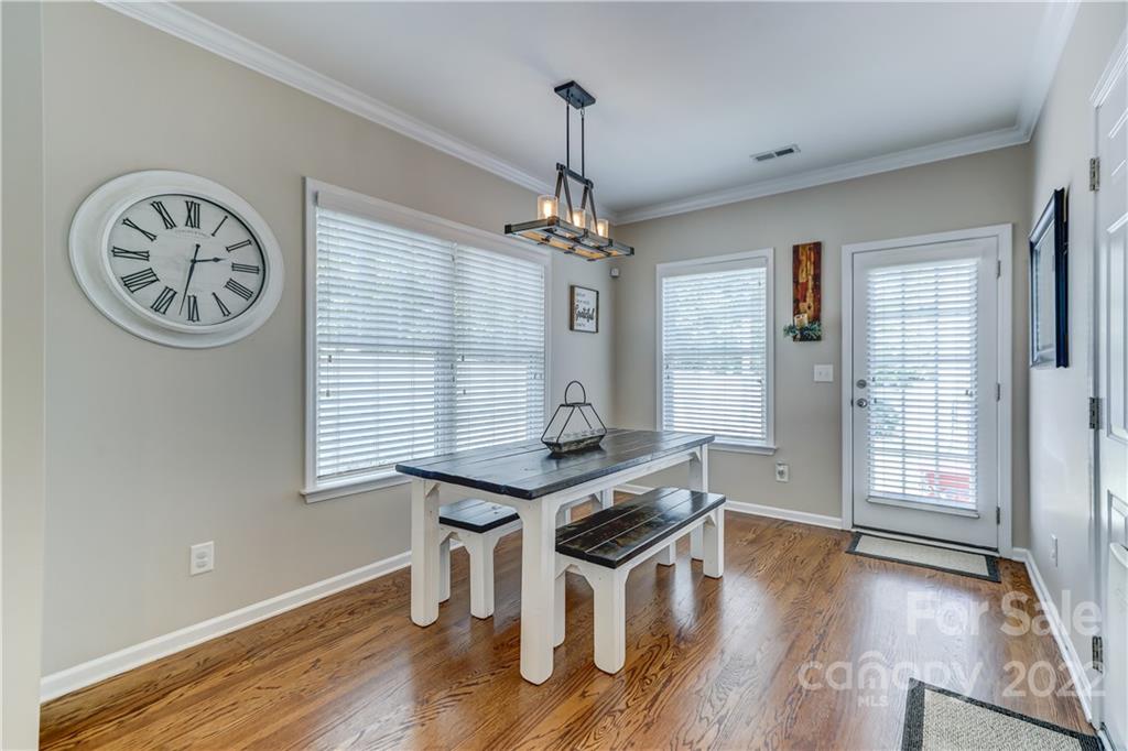 3558 Richard's Crossing Fort Mill, SC 29708 - Photo 14 of 35 a dining room with wooden floor a chandelier a wooden table and chairs