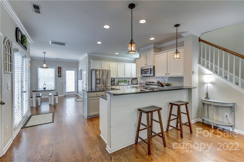 3558 Richard's Crossing Fort Mill, SC 29708 - Photo 9 of 35 a kitchen with stainless steel appliances granite countertop a stove top oven a sink a refrigerator and white cabinets with wooden floor