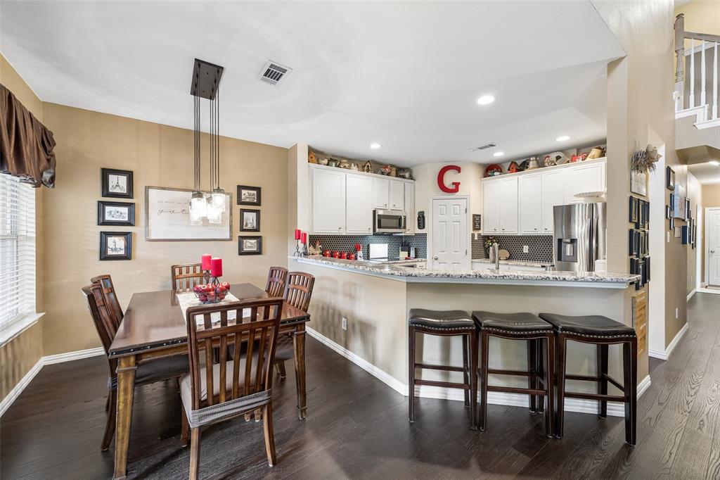 403 Springtree Road Lake Dallas, TX 75065 - Photo 12 of 34 a kitchen with stainless steel appliances granite countertop a dining table and chairs with wooden floor