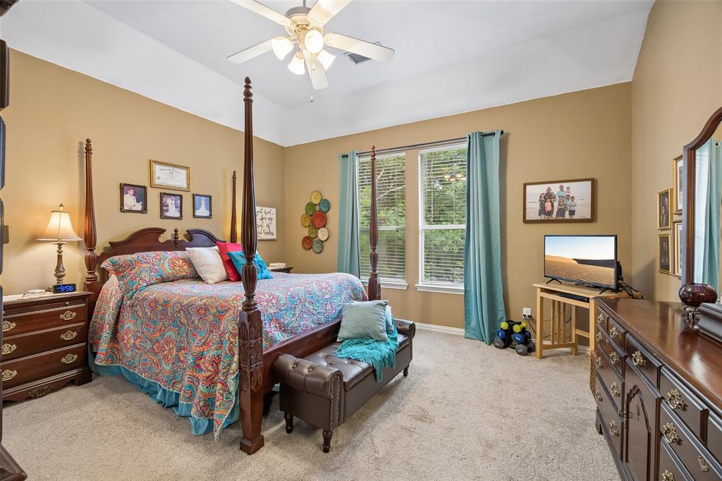 403 Springtree Road Lake Dallas, TX 75065 - Photo 18 of 34 a bedroom with a bed and a chandelier