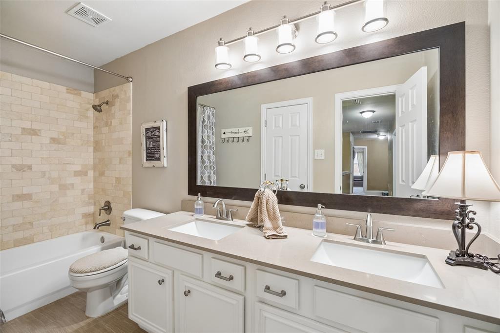 403 Springtree Road Lake Dallas, TX 75065 - Photo 27 of 34 a bathroom with a double vanity sink toilet mirror and bathtub