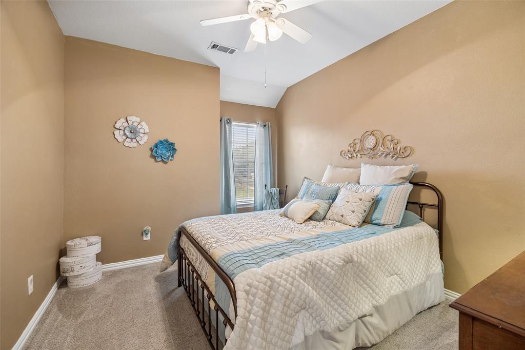 403 Springtree Road Lake Dallas, TX 75065 - Photo 29 of 34 a bedroom with a bed and a chandelier