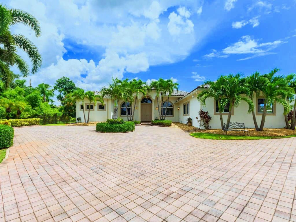 16500 Southwest 62nd Street Southwest Ranches, FL 33331 - Photo 2 of 100 a view of a house with potted plants and a yard