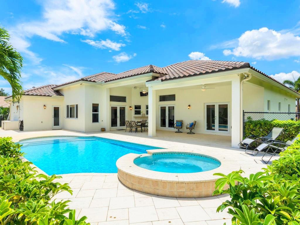 16500 Southwest 62nd Street Southwest Ranches, FL 33331 - Photo 48 of 100 a view of a white house with a swimming pool and a chairs and table in a patio