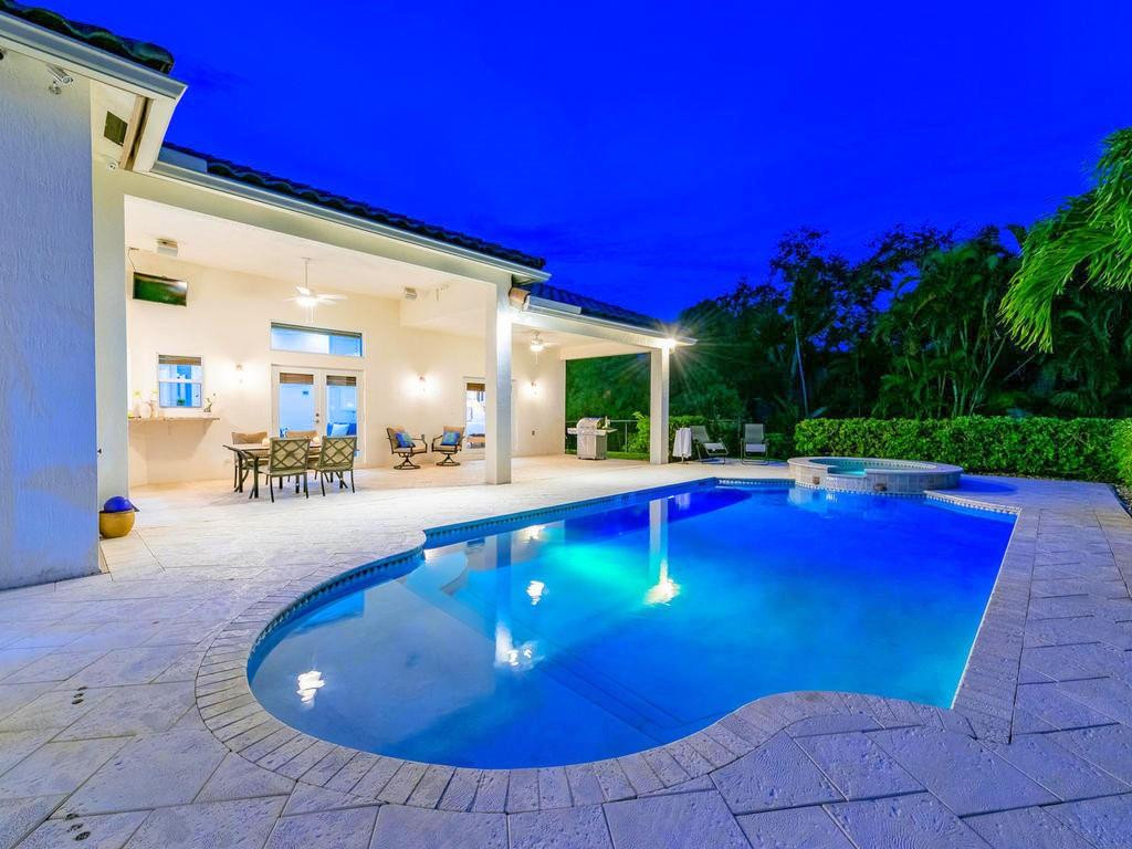 16500 Southwest 62nd Street Southwest Ranches, FL 33331 - Photo 72 of 100 a view of a swimming pool with red chairs in front of house