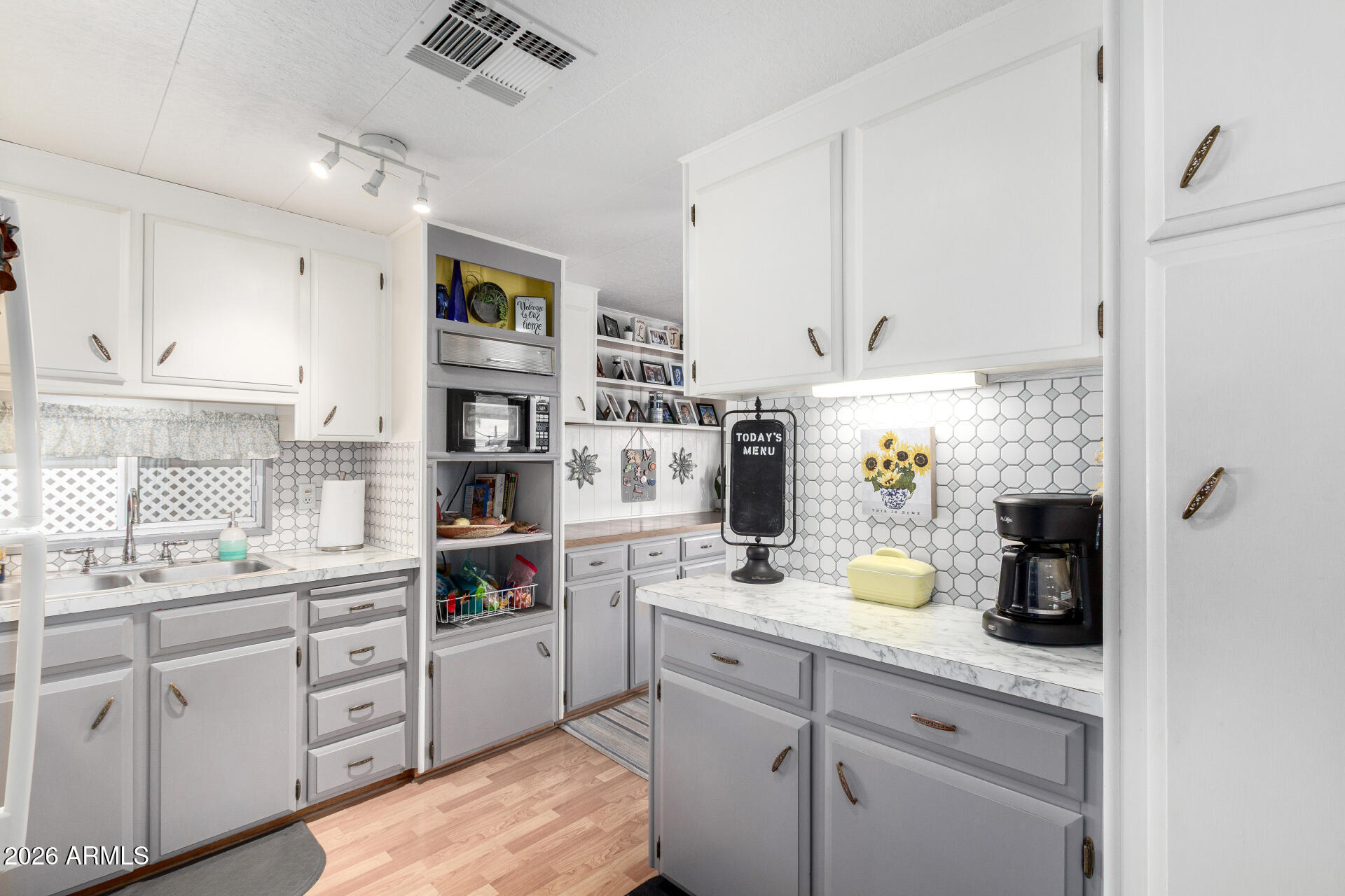 800 West Apache Trail, Unit 93 Apache Junction, AZ 85120 - Photo 5 of 28 a kitchen with a sink dishwasher and white cabinets with wooden floor
