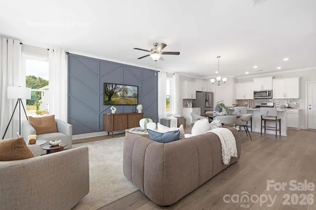 a living room with furniture kitchen view and a chandelier