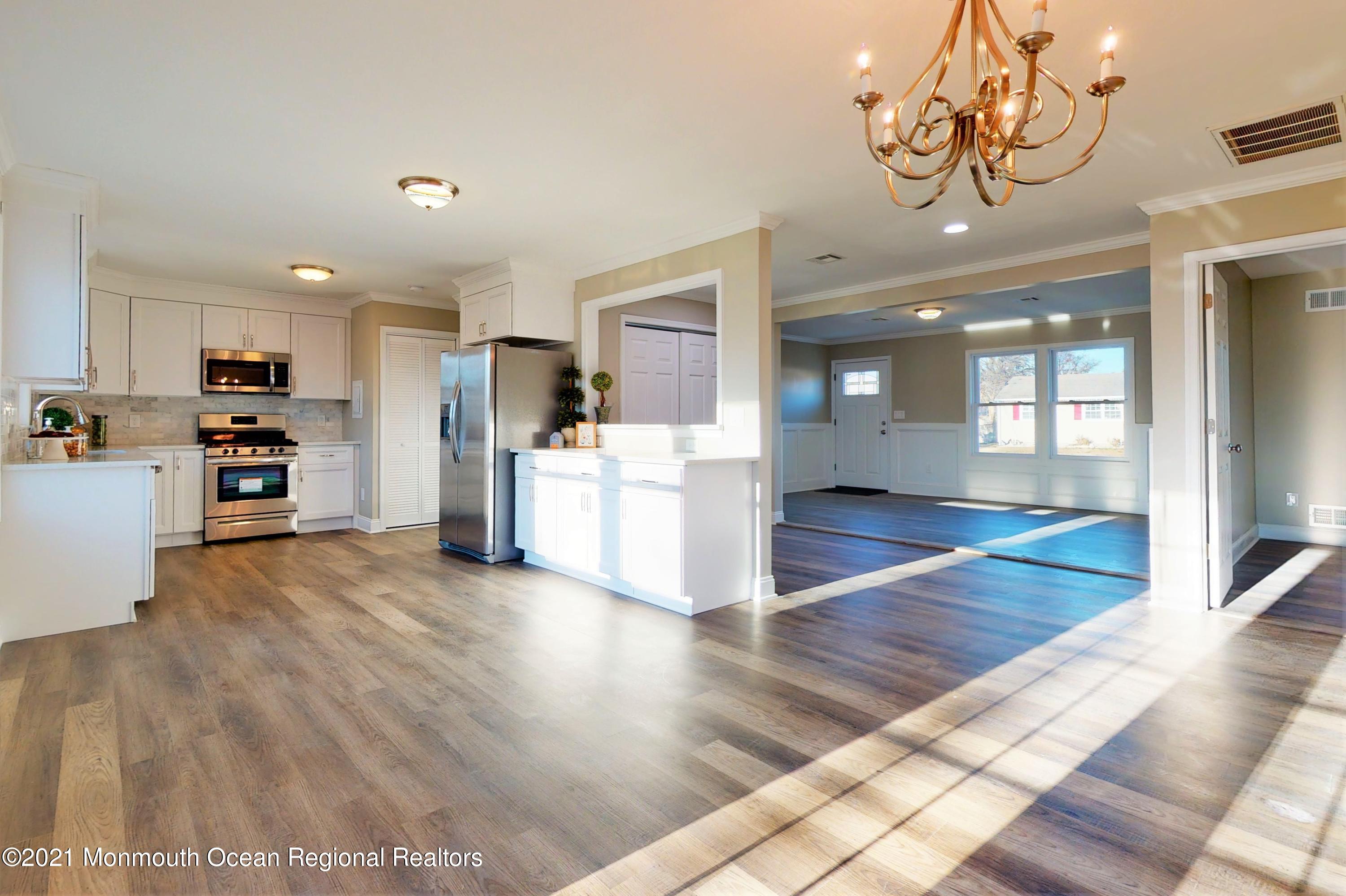 a view of a kitchen with furniture and wooden floor