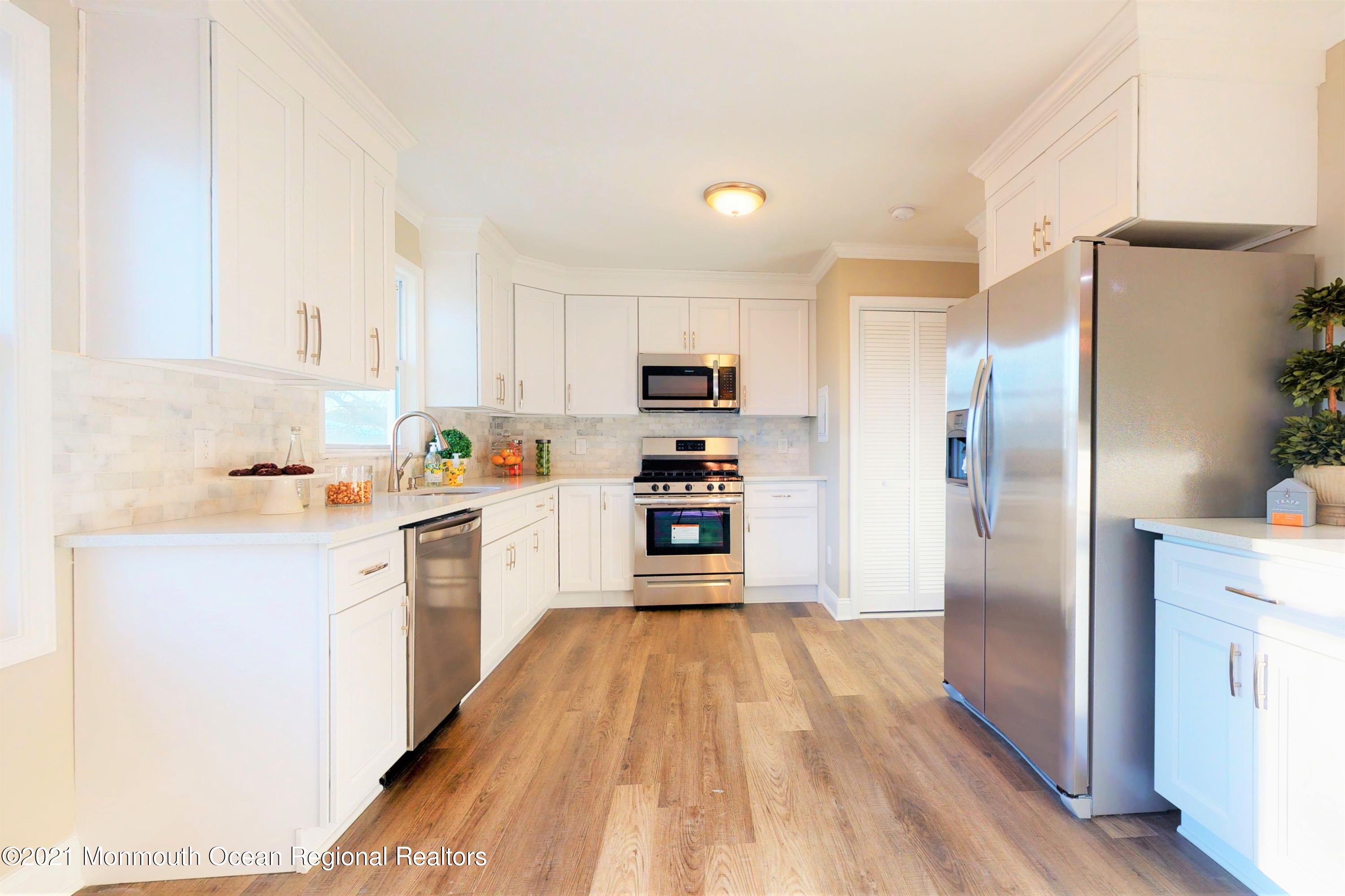 317 Stearman Road Brick, NJ 08723 - Photo 20 of 41 a kitchen with granite countertop a refrigerator oven a sink dishwasher and white cabinets with wooden floor