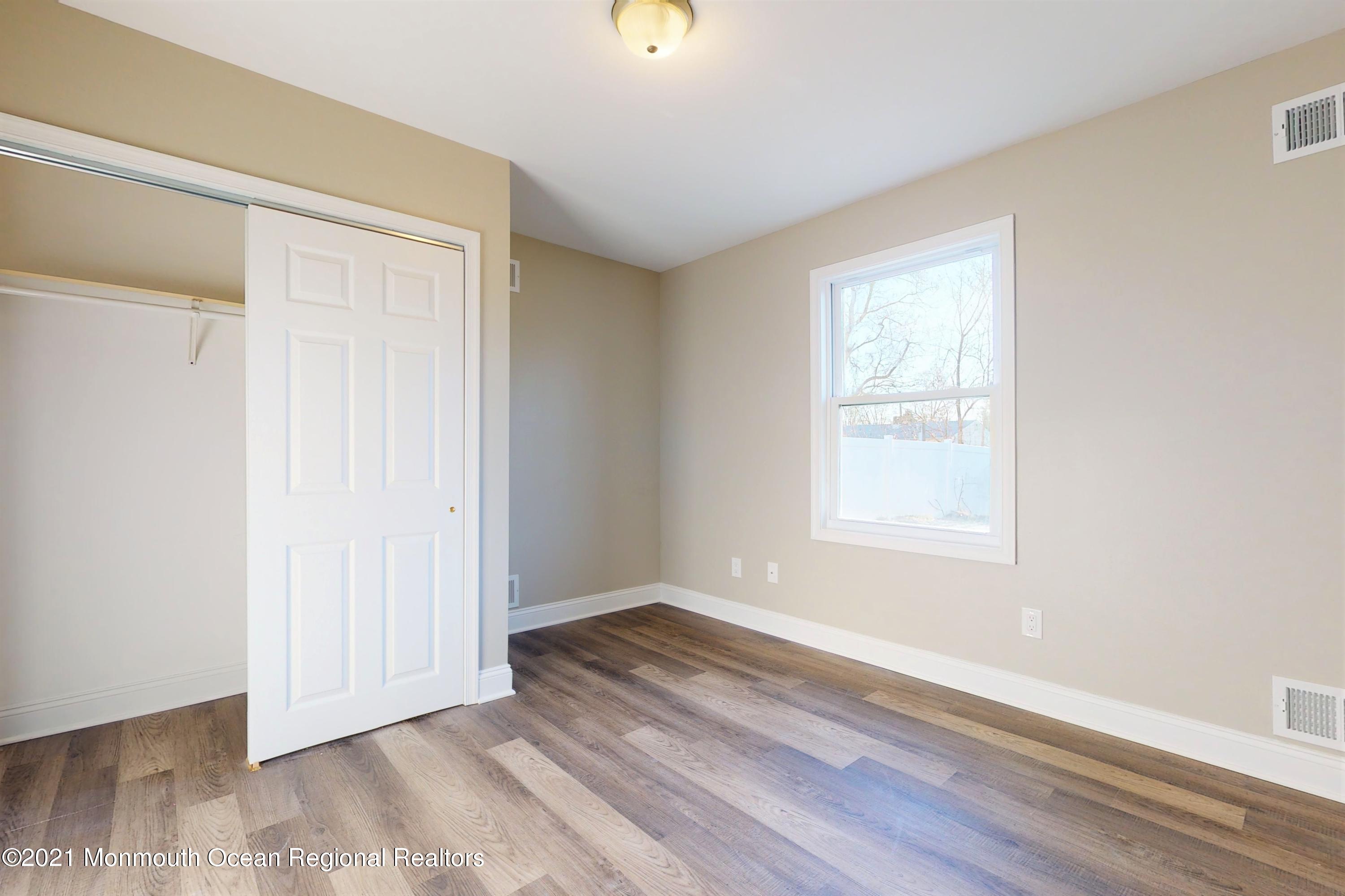 317 Stearman Road Brick, NJ 08723 - Photo 28 of 41 an empty room with wooden floor and windows