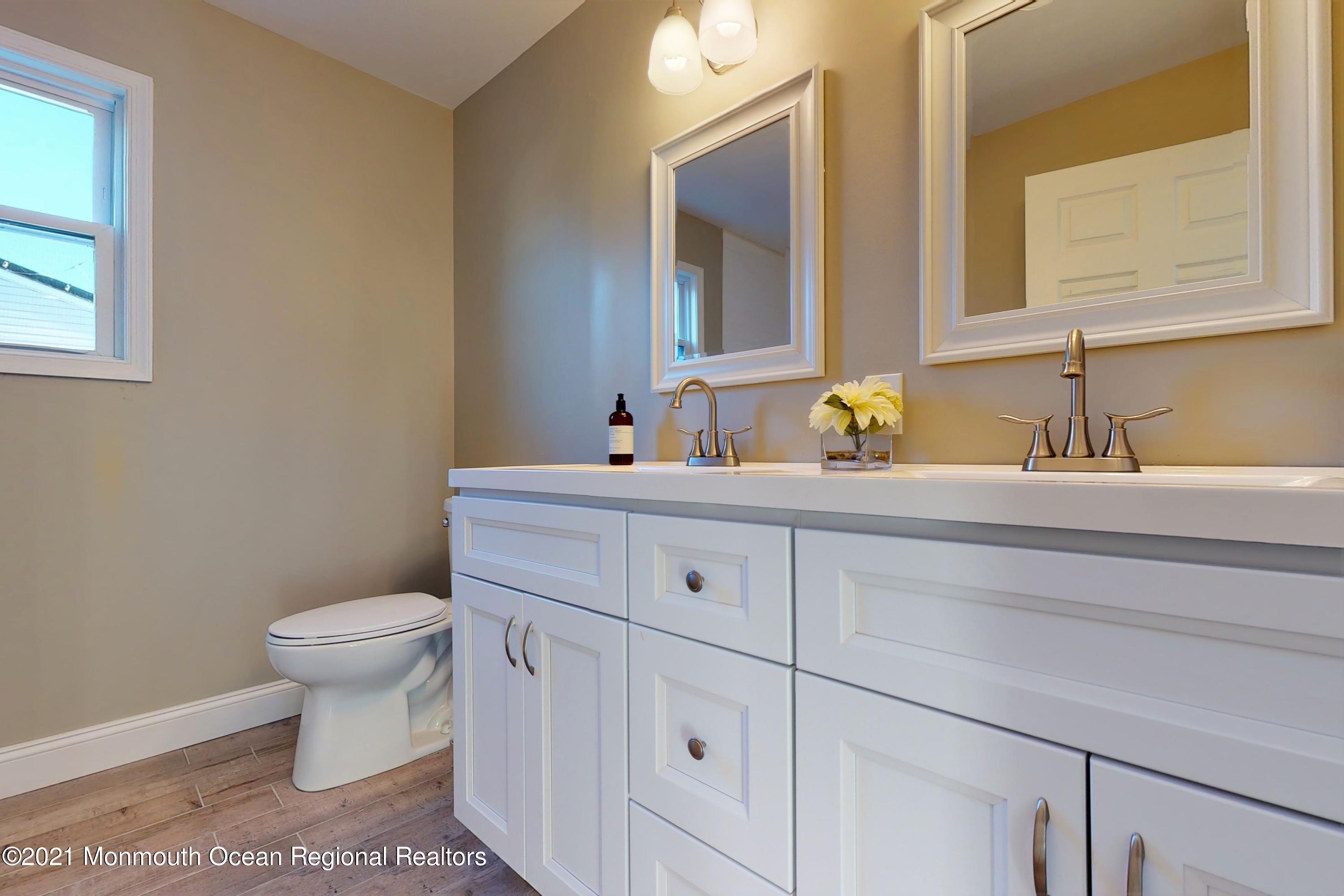 317 Stearman Road Brick, NJ 08723 - Photo 30 of 41 a bathroom with a toilet a sink and a mirror