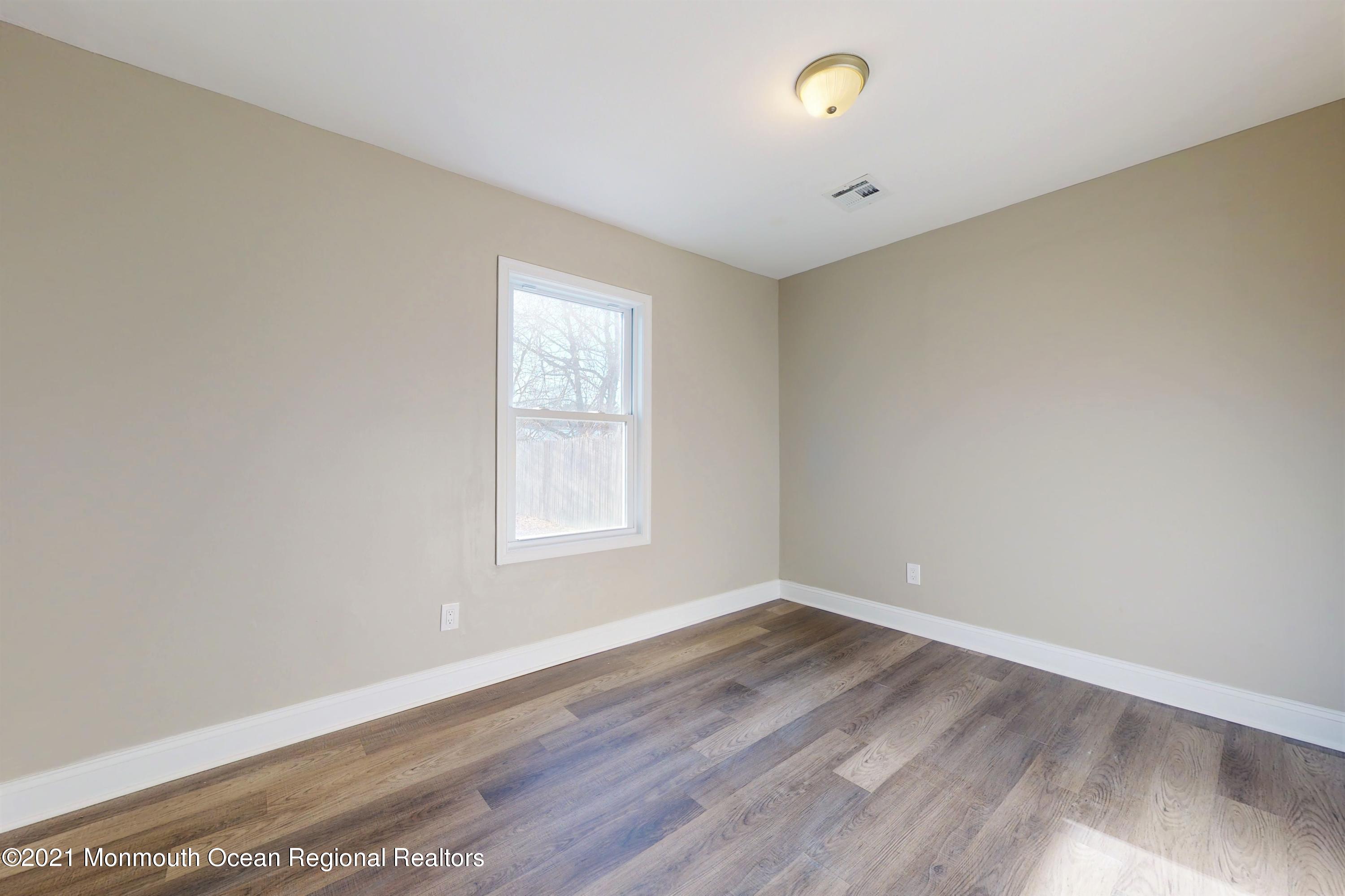 317 Stearman Road Brick, NJ 08723 - Photo 39 of 41 an empty room with wooden floor and windows
